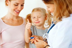 Doctor taking blood test from small patient.