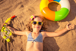 Happy child lying on the beach. Unusual top view portrait